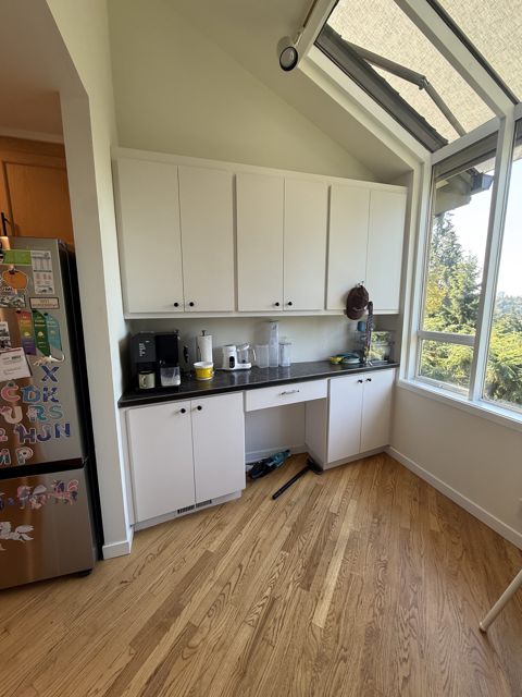 Breakfast nook with white cabinets under a vaulted ceiling