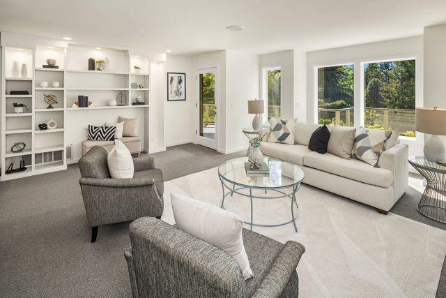 Lower-level rec room with a tall white built-in shelving wall